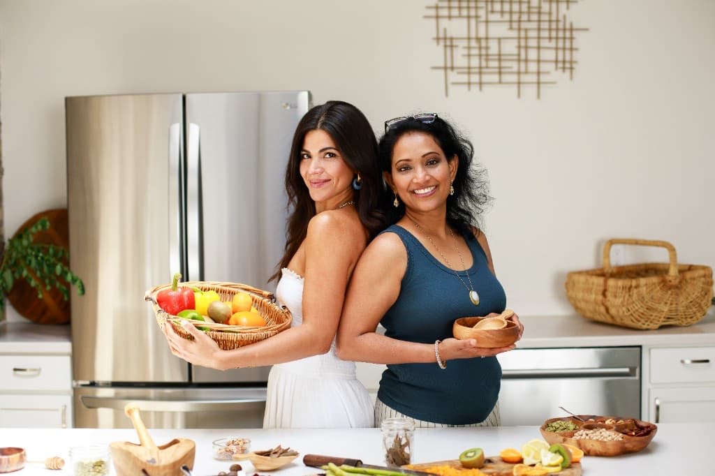 Monica Hidalgo and a collaborator in the kitchen with fresh ingredients